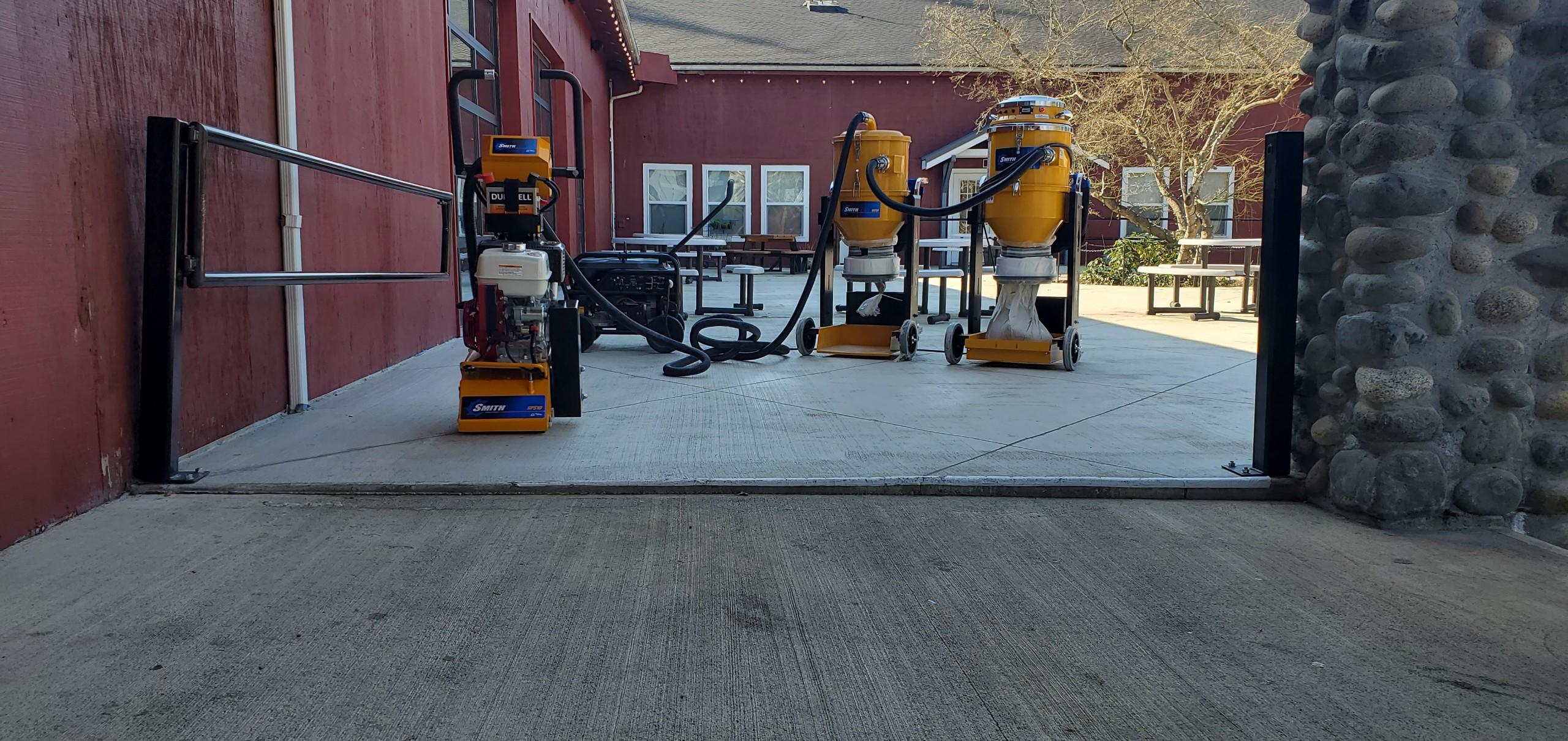 5 Diamond concrete grinder and dust collection equipment on a courtyard sidewalk